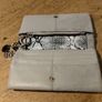 River Island clutch purse featuring a dual-texture gray flap panel design and a central dark metallic logo plate. Perfect inside. Image 6