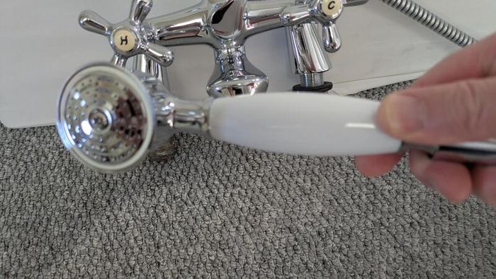 Retro bath mixer with handheld shower head.