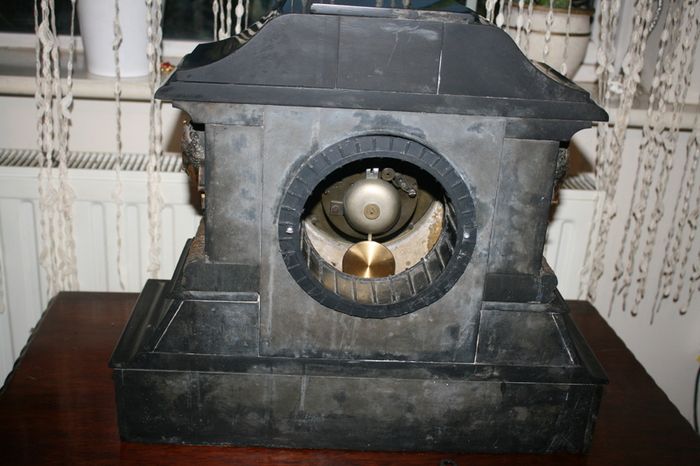 Victorian French Black Slate Mantle Clock (Very large and heavy) with bronze ornamentation Oversized. Open escarpment slate plate Roman numerals. Circa 1890s. Accented with Trojan head. Flanked by two Hellenistic ladies heads on sides. Rose cartouche mask