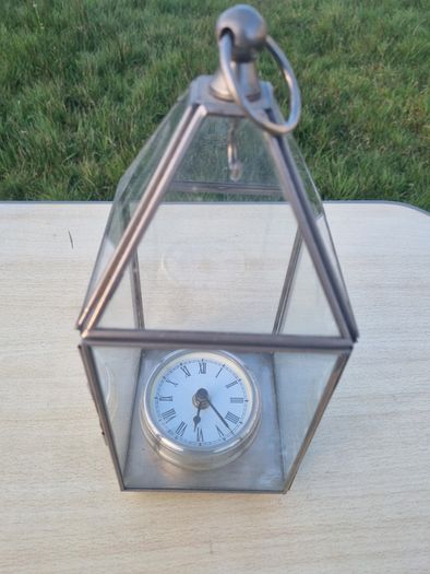 Table clock in a glass lantern.