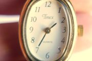 Vintage Timex womens quartz watch - gold tone oval case, white dial and black strap