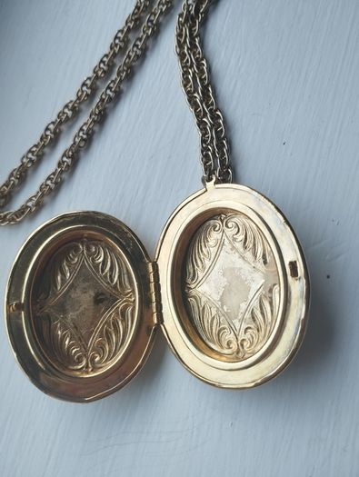 A large medallion featuring religious symbols, suspended from a long chain.