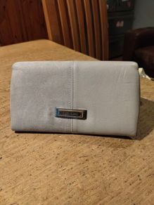 River Island clutch purse featuring a dual-texture gray flap panel design and a central dark metallic logo plate. Perfect inside.