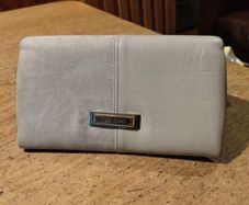 River Island clutch purse featuring a dual-texture gray flap panel design and a central dark metallic logo plate. Perfect inside.