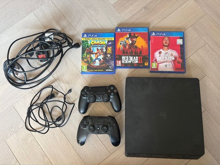 Sony PlayStation 4 console with two controllers and three games