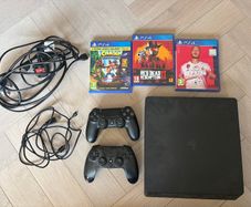 Sony PlayStation 4 console with two controllers and three games
