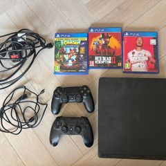 Sony PlayStation 4 console with two controllers and three games