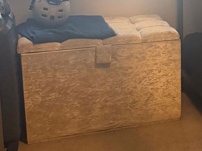 Double bed with headboard and separate storage trunk.
