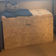 Double bed with headboard and separate storage trunk.