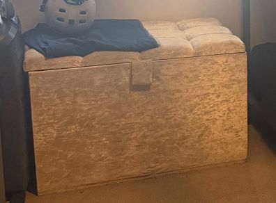 Double bed with headboard and separate storage trunk.