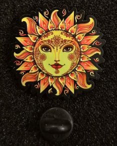 Sun,   pin back badge.