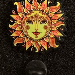 Sun,   pin back badge.