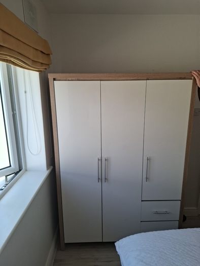 Timer and white wardrobe and bedside locker
