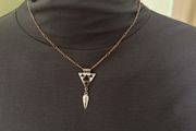 Gold tone necklace with silver tone geometric pendant