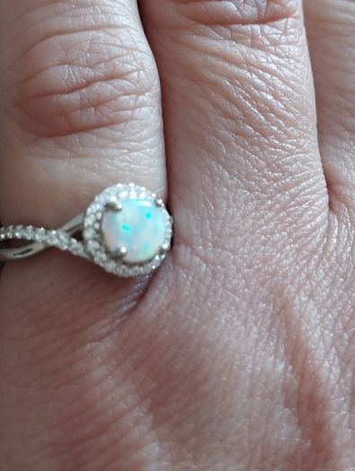 A beautiful 925 silver ring with a white lab opal surrounded by shining cubic zirconia.