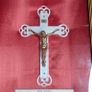 antique framed crucifix featuring a white ornamental cross with a metallic corpus of Jesus Christ mounted over a red  backing inside a gilded wooden frame. Devotional item. Image 2