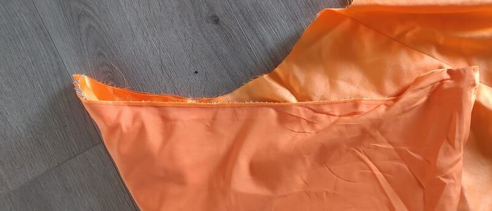 Solid orange satin look piece of fabric with beads