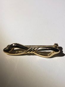 Gold bow shaped brooch