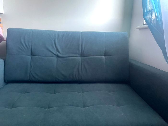 Grey fabric sofa bed with large storage compartment.