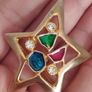 A gold star-shaped brooch. Image 6