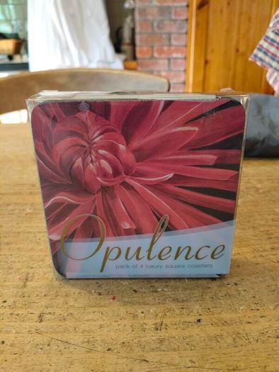 set of four Opulence brand square coasters featuring a vibrant red dahlia flower design. New in Package.