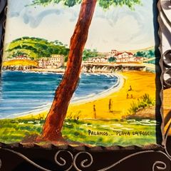 Hand painted tile from Palamos, Playa La Fosca La Fosca beach in Palamos, Costa Brava, Spain. heled in black costirorn holder