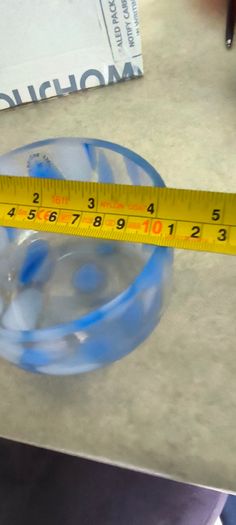 A hand-blown blue and white swirl art glass piece Small glass bowl with sticker say The phrase "EVERY PIECE IS UNIQUE" circles the clover.