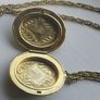 A large medallion featuring religious symbols, suspended from a long chain. Image 4