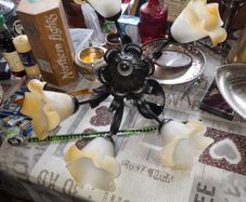 Vintage Style Chandelier with 5 Corolla Shaped shades in frosted Glass Set against a Central Foliage Structure made of black metal