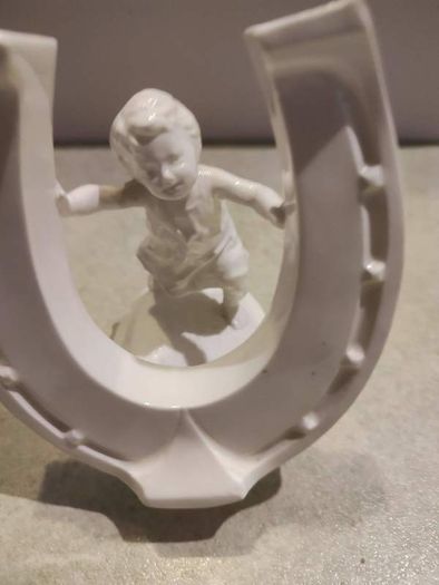 Rare find Cherub  Porcelain Horseshoe as flower vase held with child .