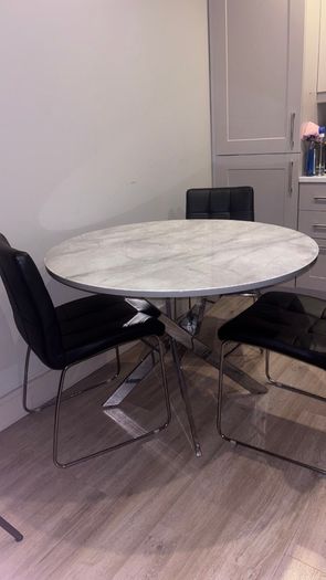Round marble-effect dining table with 4 black chairs