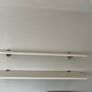 A pair of e floating wall shelves mounted on decorative metal shelf brackets. Image 2