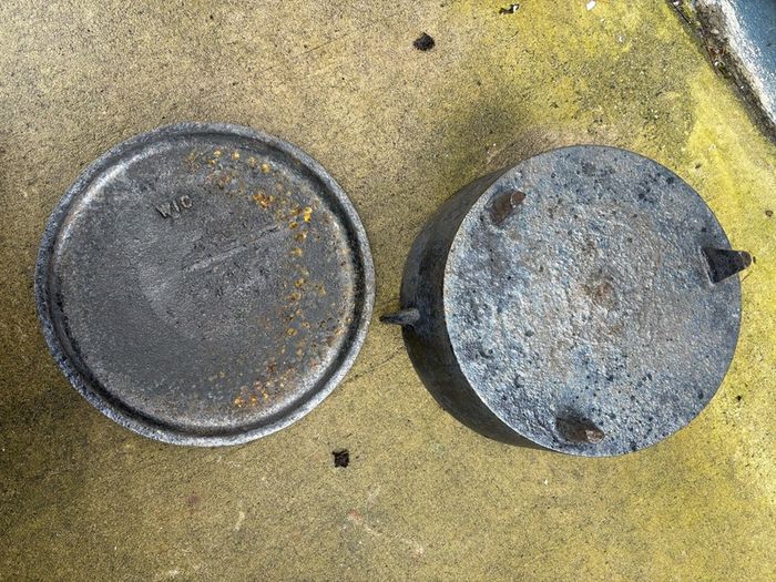Antique cast iron tri-legged dutch oven and lid.