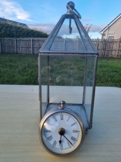 Table clock in a glass lantern.