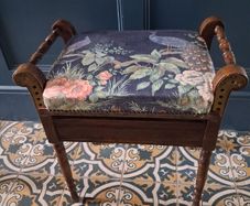 Antique piano stool upholstered in peacock fabric