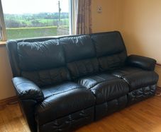 black reclining leather sofa and two armchairs