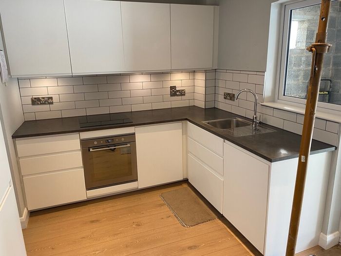 Modern white kitchen units and tall larder storage