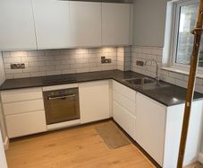 Modern white kitchen units and tall larder storage