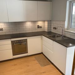 Modern white kitchen units and tall larder storage
