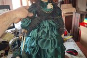 Vintage Large Victorian-style collectible Porcelain Doll featuring curly reddish-brown hair and a multi-layered emerald green satin and lace dress