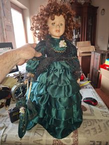 Vintage Large Victorian-style collectible Porcelain Doll featuring curly reddish-brown hair and a multi-layered emerald green satin and lace dress