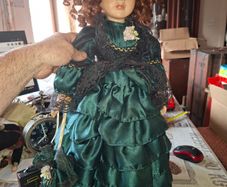 Vintage Large Victorian-style collectible Porcelain Doll featuring curly reddish-brown hair and a multi-layered emerald green satin and lace dress