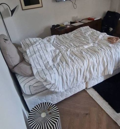 Double bed with mattress and table.