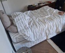 Double bed with mattress and table.