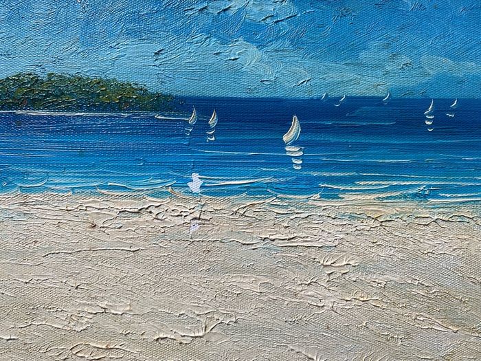 original impasto oil painting on canvas depicts a sunny coastal beach scene with sailboats on the water and a headland in the background