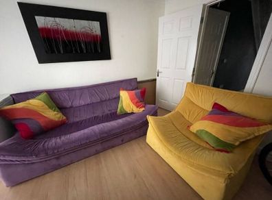 Unique Purple Curved Sofa & Yellow Accent Chair with Rainbow Cushions