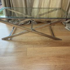 Contemporary glass top and polished metal coffee table