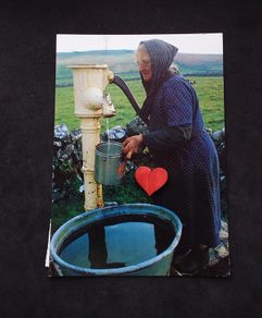 Ireland Postcard : Showing An Elderly Lady Using A Hand Pump In Rural Ireland