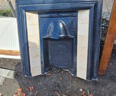 Metal and tiled fireplace with wooden mantle. With 4 panel internal door