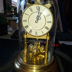 West Germany Estyma Anniversary Clock, featuring a brass finish and a rotating pendulum under a Glass Dome,